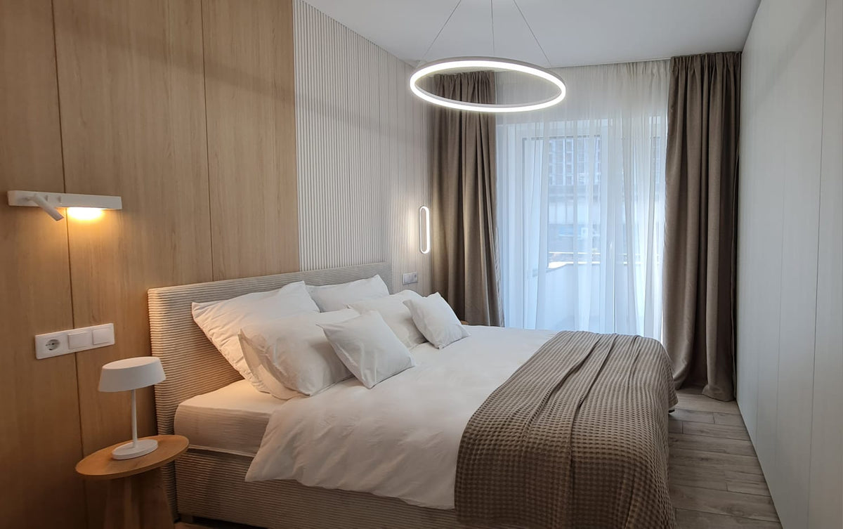 Draperii bej și perdea albă SereDesign într-un dormitor